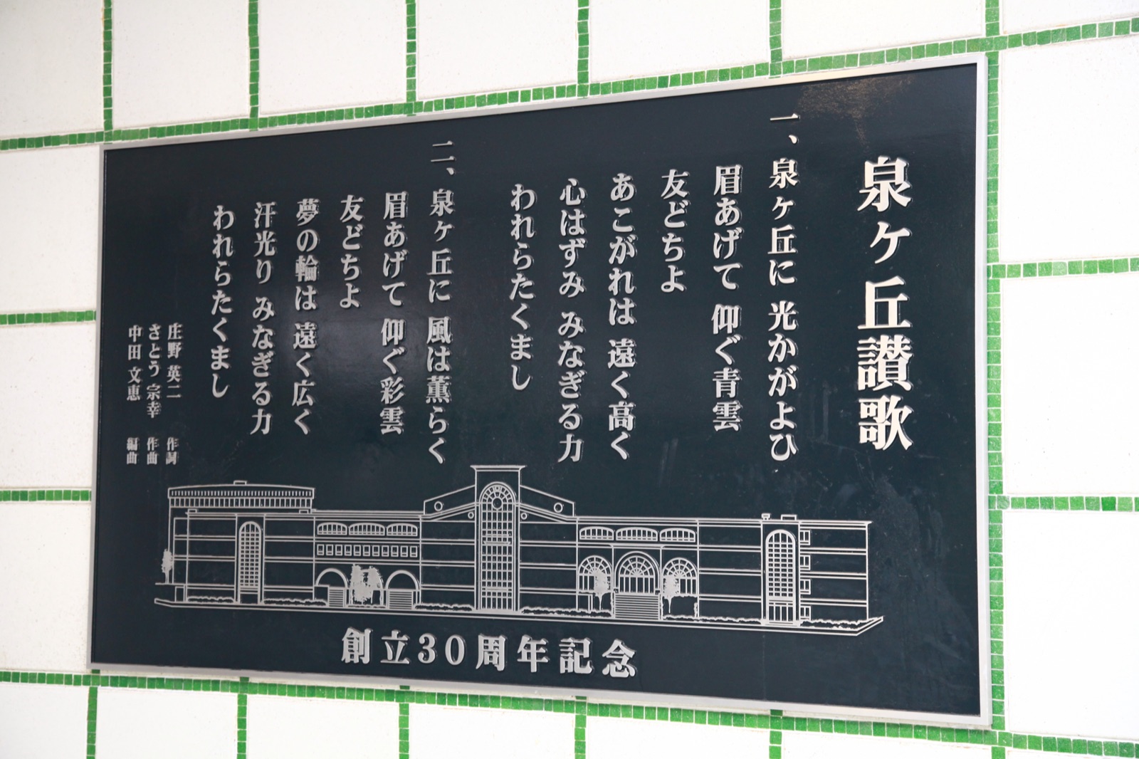 泉ヶ丘讃歌と校舎が描かれた創立30周年記念の銘板